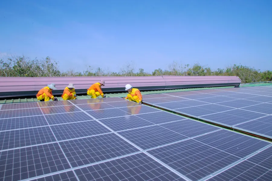 Installatore che fissa un pannello solare sulla struttura di un tetto